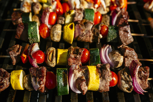 Chicken, steak and vegetable skewers on a grill