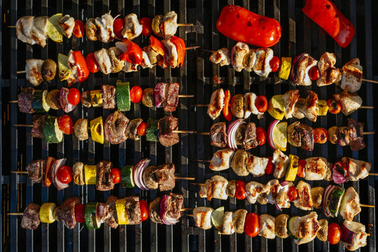 Chicken, steak and vegetable skewers on a grill