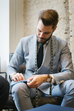 Men's Fashion - Portrait of Stylishly Dressed Young Male Tailor Folding Pocket Square