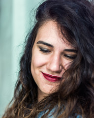 Closeup portrait of a young caucasian girl with curly hair with dreamy smiling expression on her face and closed eyes