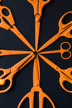 Orange various scissors arranged on black background