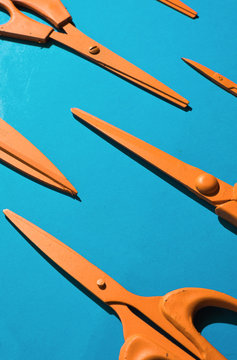 Orange scissors on blue background