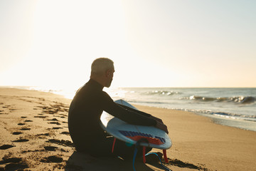 Side view of surfer with board on beach