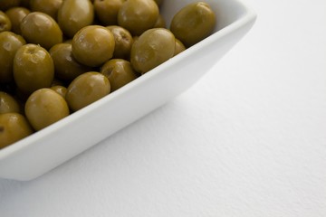 Close up of green olives in container