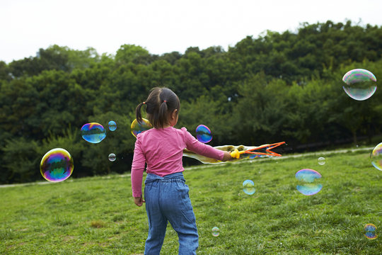 little asian girl playing soap bubble outdoor