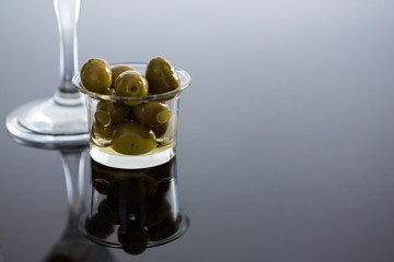 Glass with olives on table