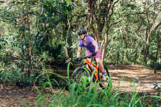 Female mountain bike rider in a forest trail
