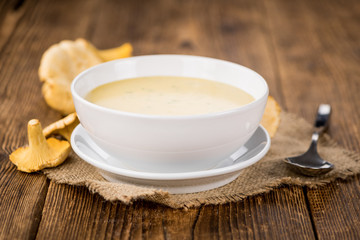 Chanterelle Soup on wooden background; selective focus