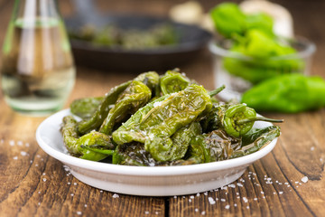 Pimientos de Padron on wooden background; selective focus