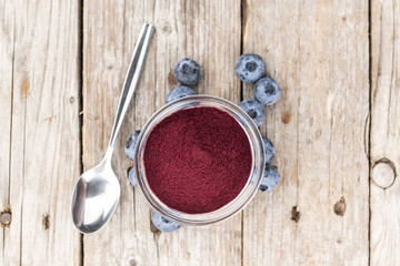 Portion of Blueberry Powder on wooden background, selective focus