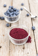 Wooden table with Blueberry Powder, selective focus
