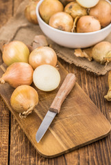 Wooden table with White Onions, selective focus