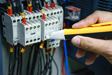 Checking voltage in switchboard with a detector. Electrical background