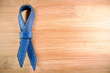 Blue prostate cancer ribbon awareness on wood background.
