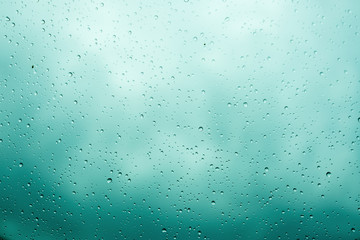 Rain drops on glass selective focus. Cloudy sky background