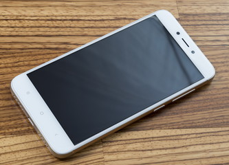Xiaomi Redmi 4X gold smartphone on wooden background