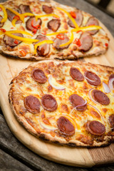 cooking pizza in an outdoor wood fired pizza oven