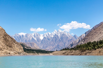 Fototapeta na wymiar A stunning view of the Karakoram mountain ranges from the boat across the Attabad lake that shines in emerald color