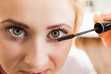 Woman getting eyelashes makeup done