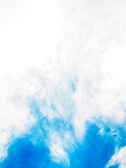 Ink swirl in water isolated on white background. The paint in the water. Soft dissemination a droplets of blue ink in water close-up. Abstract background. Soft focus.