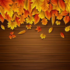 Naklejka na ściany i meble Wooden background with autumn leaves falling