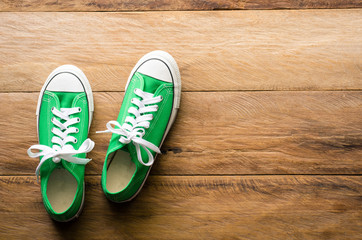 Green sneakers on wooden floors.-lifestyle