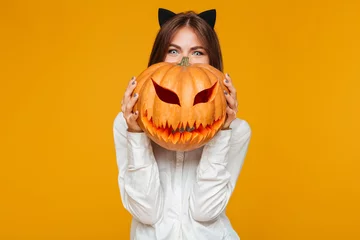 Fototapeten Happy young woman dressed in crazy cat halloween costume © Drobot Dean