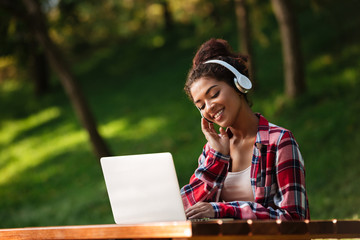 African woman sitting outdoors in park.