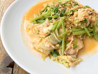 Suki without broths, stir fried mixed vegetable and meat in sukiyaki sauce on white plate on wooden table. Vegetarian Food, healthy food