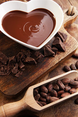 Chocolate cream melted and chocolate pieces on wooden table