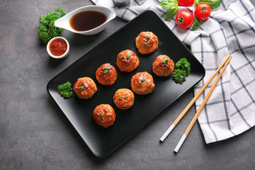 Plate with delicious meatballs on table