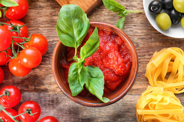Composition with tasty tomato sauce for pasta on table