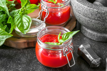 Glass jar with tasty tomato sauce for pasta on table