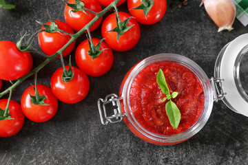 Glass jar with tasty tomato sauce for pasta on table