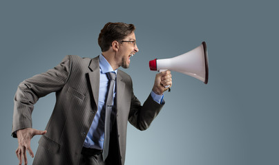 Fototapeta premium Businessman in gray suit with megaphone