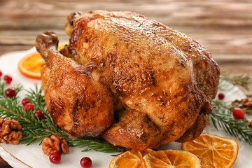 Roasted turkey with orange and fir tree branches on plate