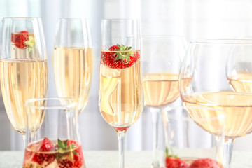 Glasses of delicious wine with strawberry on table