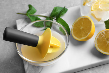 Composition with fresh citrus fruit and squeezer on table