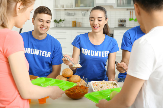 Teen Volunteers Serving Food For Homeless People Indoors