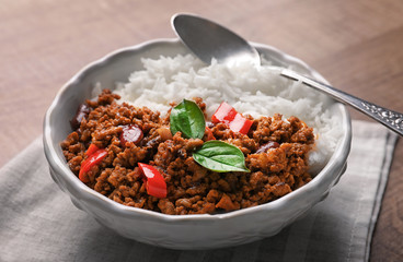 Chili con carne served with rice in bowl on table