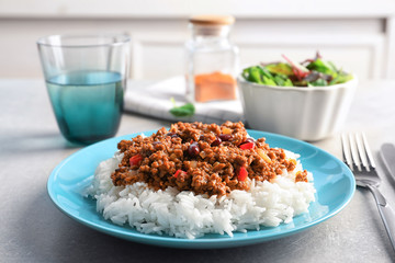 Chili con carne served with rice on dinner table
