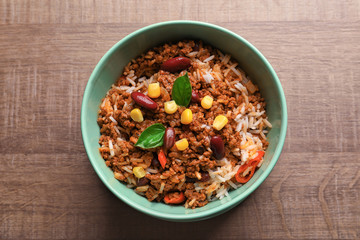Chili con carne in bowl on wooden background