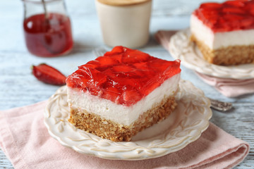 Plate with delicious strawberry pretzel salad on table