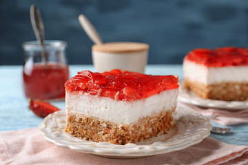 Plate with delicious strawberry pretzel salad on table