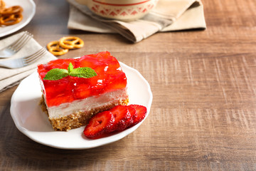 Plate with delicious strawberry pretzel salad on table