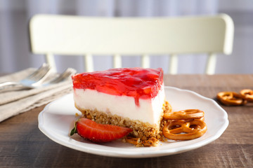 Plate with delicious strawberry pretzel salad on table
