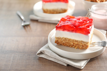 Plate with delicious strawberry pretzel salad on table