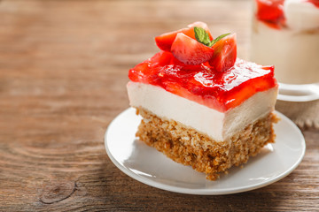 Plate with delicious strawberry pretzel salad on table