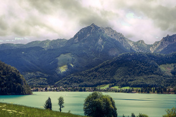 Obraz premium calm lake on a cloudy day surrounded by mountains in Alps