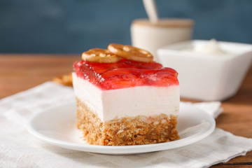 Plate with delicious strawberry pretzel salad on table